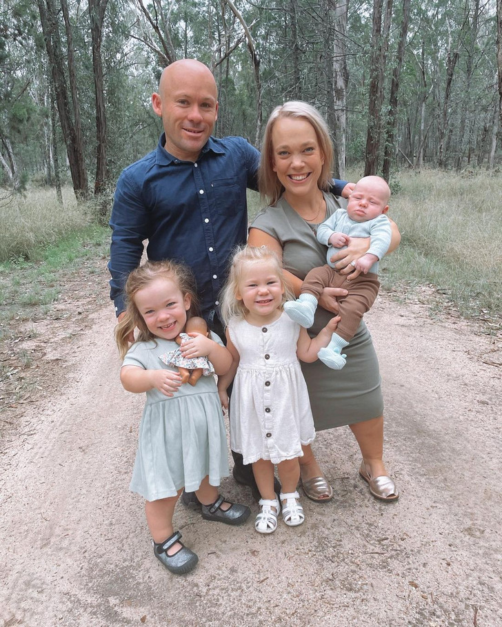 A couple with dwarfism with their two infant daughters and a baby boy on the mother's arms.